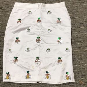 White skirt with pineapples embroidered on it.